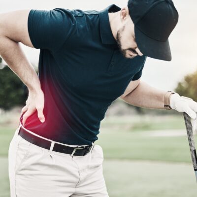 Sports, muscle and golf, man with back pain during game on course, massage and relief in health and wellness. Green, hands on injury in support and golfer with body ache at golfing workout on grass.